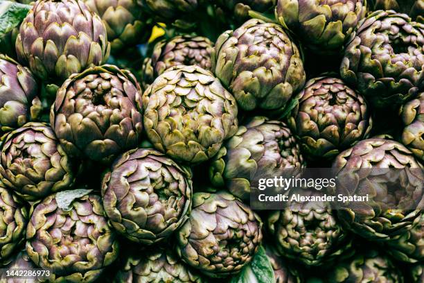 full frame shot of fresh artichokes on the farmer's market - artichoke stock pictures, royalty-free photos & images