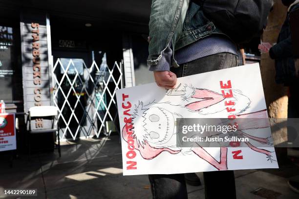 Striking Starbucks worker holds a sign outside of a Starbucks coffee shop during a national strike on November 17, 2022 in San Francisco, California....