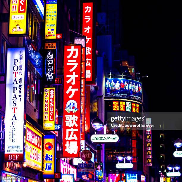 signs at night in the shibuya ward of tokyo, japan - kanji stock pictures, royalty-free photos & images