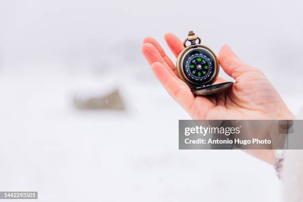 hand holding a compass in the snow - drawing compass fotografías e imágenes de stock