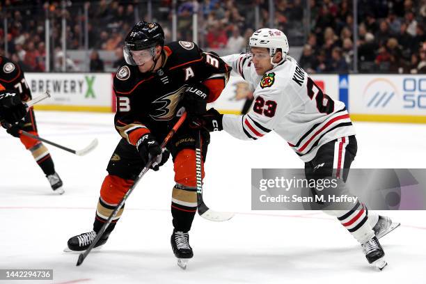 Philipp Kurashev of the Chicago Blackhawks pushes off of Jakob Silfverberg of the Anaheim Ducks during the second period of a game at Honda Center on...