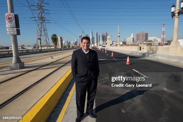 With the Downtown Skyline and City Hall behind him City Council Member José Huizar stands on the 1st Street Bridge and smiles with his hands in his...