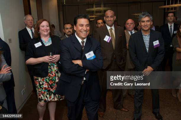 City Council Member José Huizar standing with a group of businessmen and women laughs while listening at a Central City Association reception on...