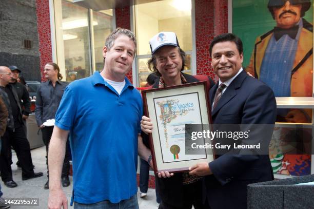 On Broadway outside Two Boots pizza City Council Member José Huizar presents a city plaque to partners Joe Baxley and Phil Hartman for the successful...