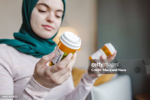 close-up photo of a young woman holding a medicine pill bottle - prescription label stock pictures, royalty-free photos & images