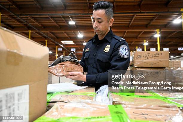 Carson, CA U.S. Customs and Border Protection officer Angel Villagrana unboxes counterfeit products seizured at the Los Angeles/Long Beach Seaport...
