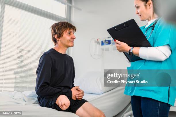 young amputated leg man talking to his physical therapist at a hospital - diabetes feet stock pictures, royalty-free photos & images