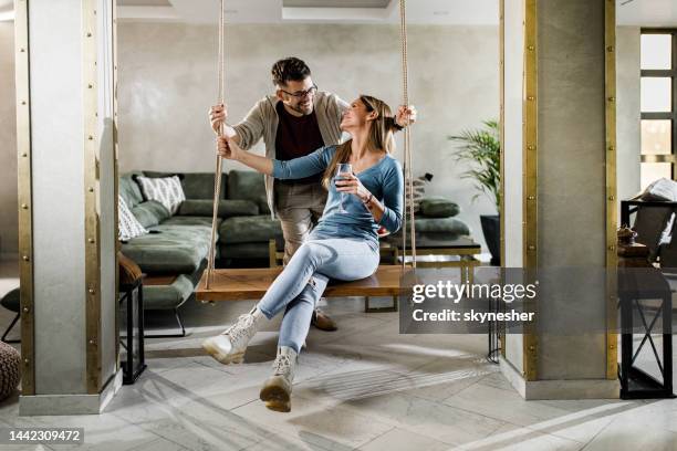 happy couple talking while enjoying in their time together at home. - couple swinging stock pictures, royalty-free photos & images