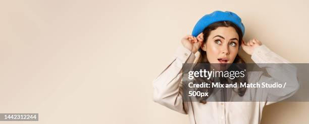 stylish modern girl put on trendy hat on head and smiling,going out - carrying on head stockfoto's en -beelden