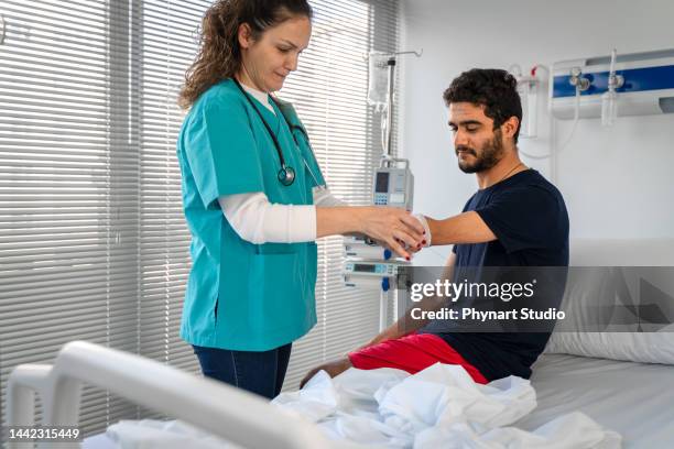 doctor wrapping bandage on  arm amputation - amputee rehab stock pictures, royalty-free photos & images