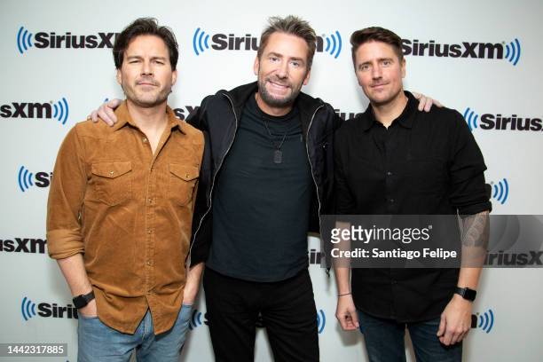 Ryan Peake,Chad Kroeger and Daniel Adair of Nickelback visit SiriusXM Studios on November 17, 2022 in New York City.