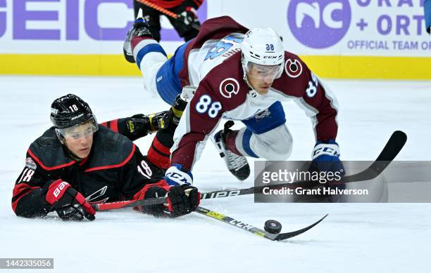 Jack Drury of the Carolina Hurricanes battles Andreas Englund of the Colorado Avalanche for the puck during the first period of their game at PNC...
