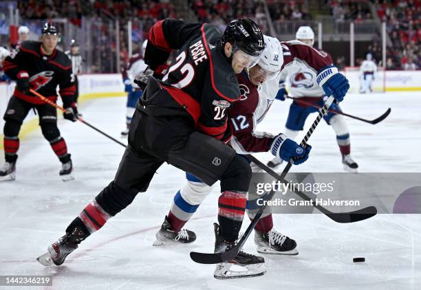 Brett Pesce of the Carolina Hurricanes and Jason Megra of the Colorado Avalanche battle for the puck during the second period of their game at PNC...
