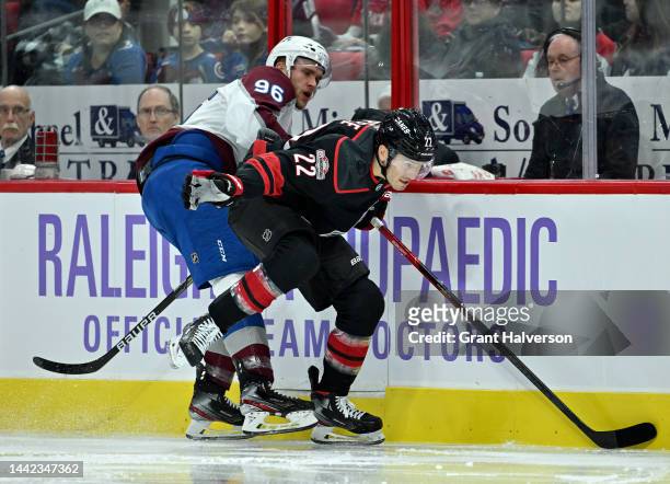 Mikko Rantanen of the Colorado Avalanche grabs Brett Pesce of the Carolina Hurricanes as they chase down a loose puck during the second period of...