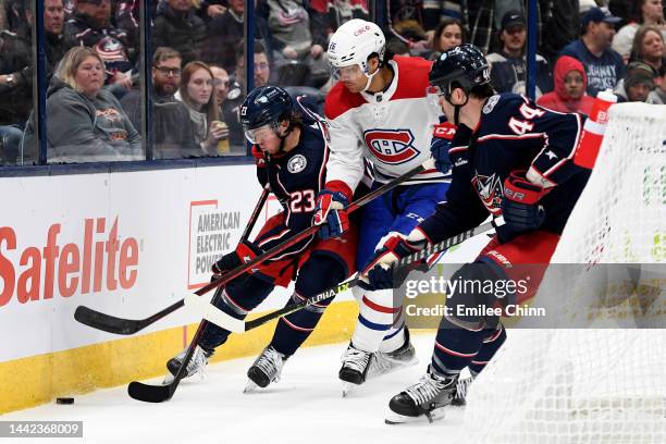 Jake Christiansen and Erik Gudbranson of the Columbus Blue Jackets compete for the puck with Johnathan Kovacevic of the Montreal Canadiens during the...