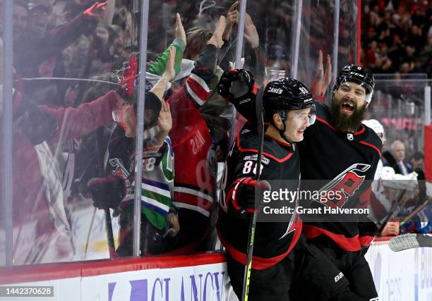 Martin Necas celebrates with teammate Brent Burns of the Carolina Hurricanes after scoring a third period goal against the Colorado Avalanche during...