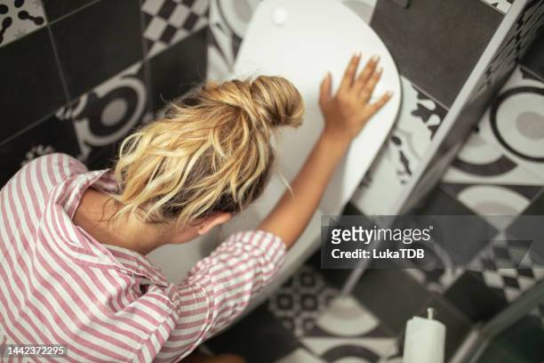 an unrecognizable woman vomits in the bathroom - woman toilet stock pictures, royalty-free photos & images