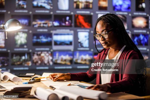 現代のオフィスの机で青写真に取り組む若い女性建築家 - ジャーナリスト ストックフォトと画像