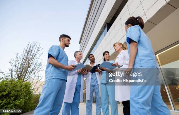 attending talking to a group of healthcare workers outside the hospital - civil imagens e fotografias de stock