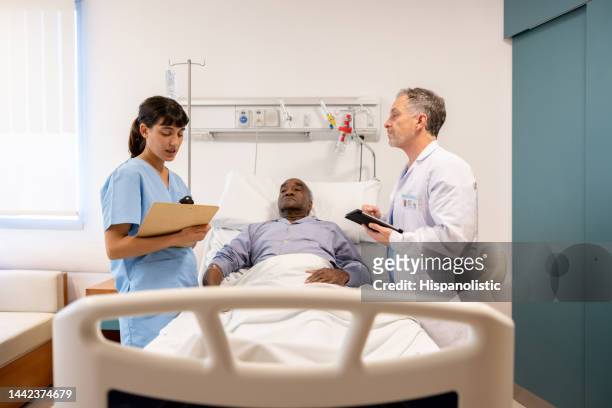 nurse reading the medical chart of a patient to a doctor at the hospital - post operation stock pictures, royalty-free photos & images