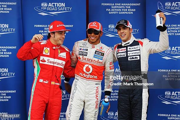 Pole sitter Lewis Hamilton of Great Britain and McLaren celebrates in parc ferme with second placed Pastor Maldonado of Venezuela and Williams and...
