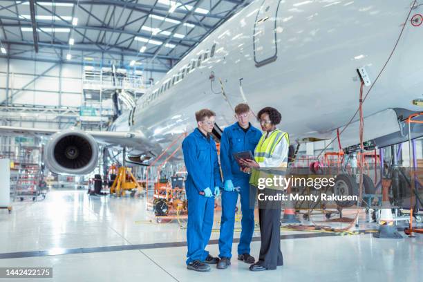 apprentice aircraft maintenance engineers with supervisor in maintenance hangar - aviation worker stockfoto's en -beelden