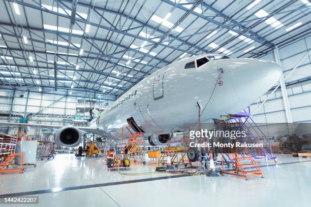 large aircraft in aircraft maintenance hangar - hanger foto e immagini stock