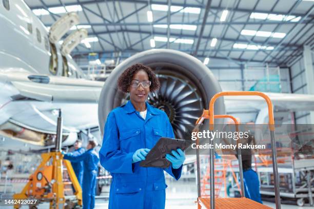 portrait of female aircraft maintenance engineer in aircraft hangar - airline industry stock-fotos und bilder