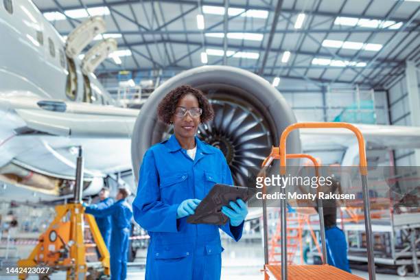 portrait of female aircraft maintenance engineer in aircraft hangar - aviation worker stockfoto's en -beelden