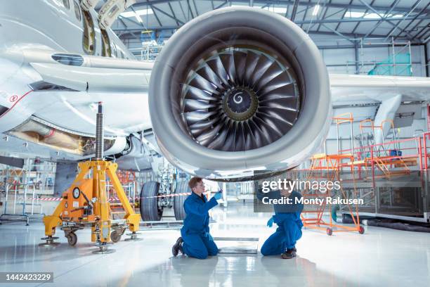 apprentice aircraft maintenance engineers inspecting large jet engine - technicien-de-maintenance photos et images de collection