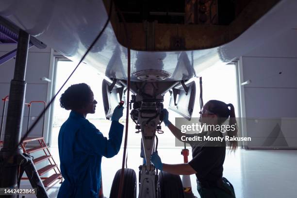 female aircraft engineers inspecting landing gear on large jet - aviation worker stock pictures, royalty-free photos & images