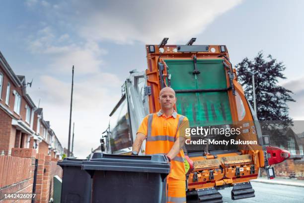 portrait of refuse collector with bin and refuse truck - rubbish lorry stock pictures, royalty-free photos & images