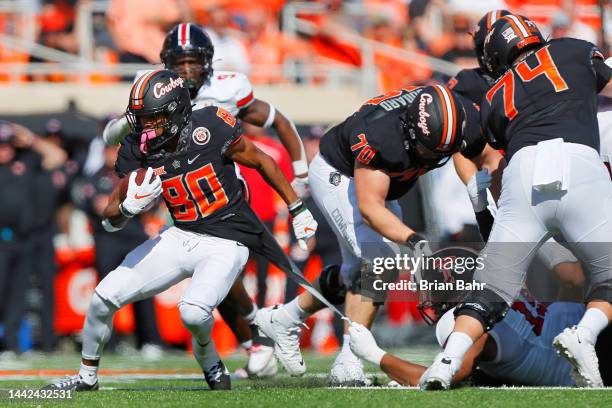 Wide receiver Brennan Presley of the Oklahoma State Cowboys breaks a shirt tail tackle by outside linebacker Tyree Wilson of the Texas Tech Red...