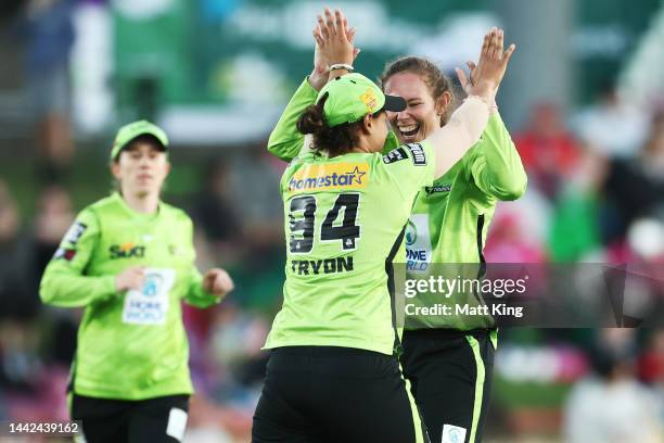 Sam Bates of the Thunder celebrates with team mates after taking the wicket of Alyssa Healy of the Sixers during the Women's Big Bash League match...