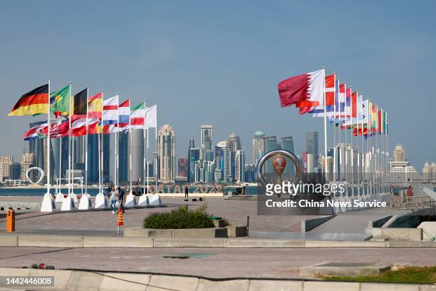 Flags of participating teams flutter in front of the "World Cup Countdown Clock" for the FIFA World Cup Qatar 2022 on the Corniche Promenade on...