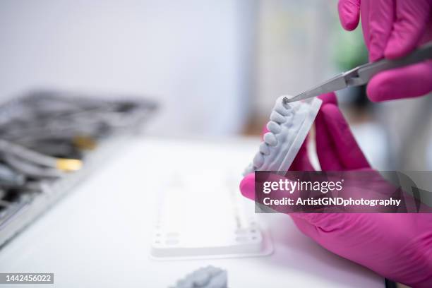 orthodontist making a layout of braces on a denture mold. - luva cor de rosa imagens e fotografias de stock