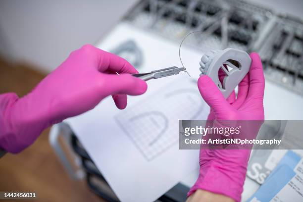 orthodontist working on dentures. - bent hand stock pictures, royalty-free photos & images