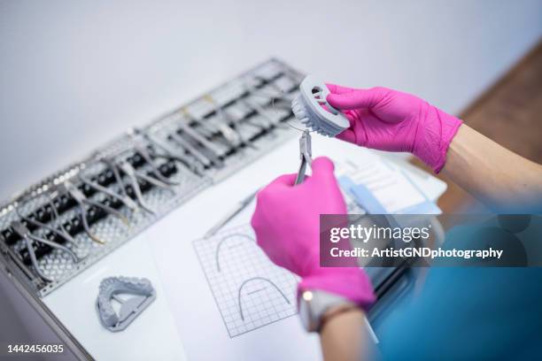 putting braces on a dental layout. - pink colour scheme stock pictures, royalty-free photos & images