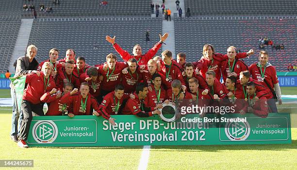 The team of Freiburg celebrates with the trophy at Olympic Stadium after winning the DFB Juniors Cup final between Hertha BSC Berlin and SC Freiburg...