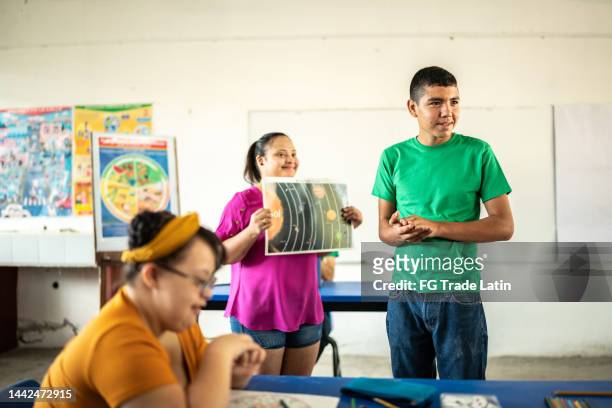 pair of special students giving an astronomy presentation in the classroom at school - boy in briefs stock pictures, royalty-free photos & images