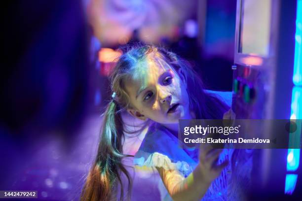 little girl presses the button on the slot machine neon night light close-up - button craft stock pictures, royalty-free photos & images