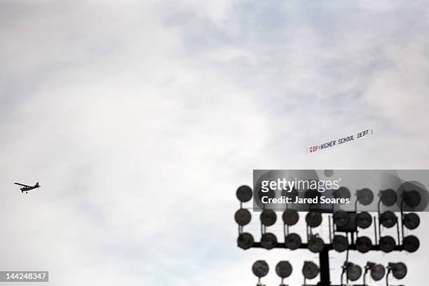 An airplane with an anti-GOP slogan flies above as Republican presidential candidate and former Massachusetts Gov. Mitt Romney delivers the...