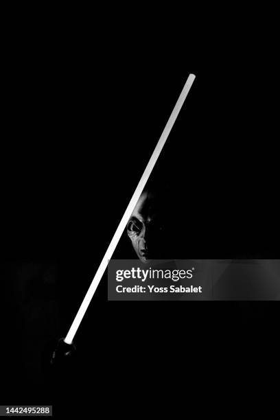 alien with a laser sword looking into the camera - laser sword stock pictures, royalty-free photos & images