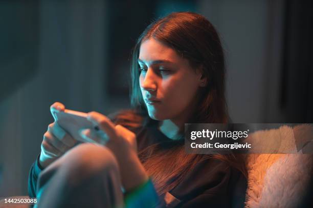 smartphone games - alleen één tienermeisje stockfoto's en -beelden