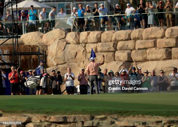 Richie Ramsay of Scotland acknowledges the crowds after picking his ball out of the hole after holing his third shot from almost 200 yards for an...
