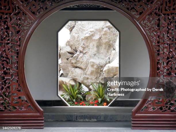 a study in symartry of rocks, plants and doorways in zhan yuan garden, nanjing, china - oriental garden stock pictures, royalty-free photos & images