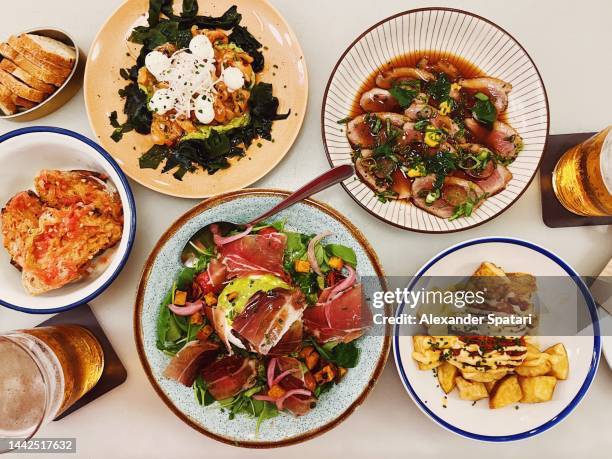 high angle view of various tapas dishes in a restaurant, barcelona, spain - barcelona tapas stock pictures, royalty-free photos & images