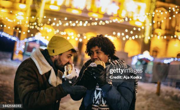 freunde, die street food in einer winternacht genießen. - frost bite stock-fotos und bilder