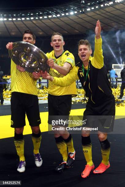 Sebastian Kehl, Sven Bender and Lukasz Piszczek of Dortmund celebrate with the trophy after winning 5-2 the DFB Cup final match between Borussia...