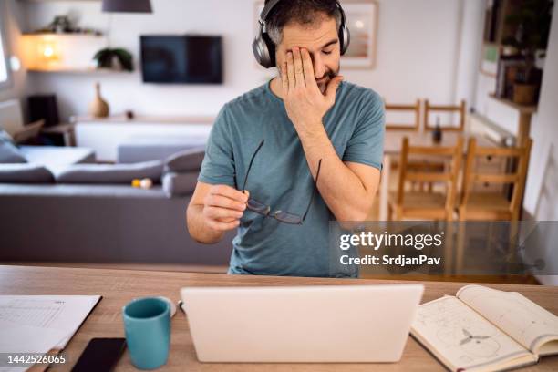 tired caucasian man working from home on laptop - sore eyes stock pictures, royalty-free photos & images